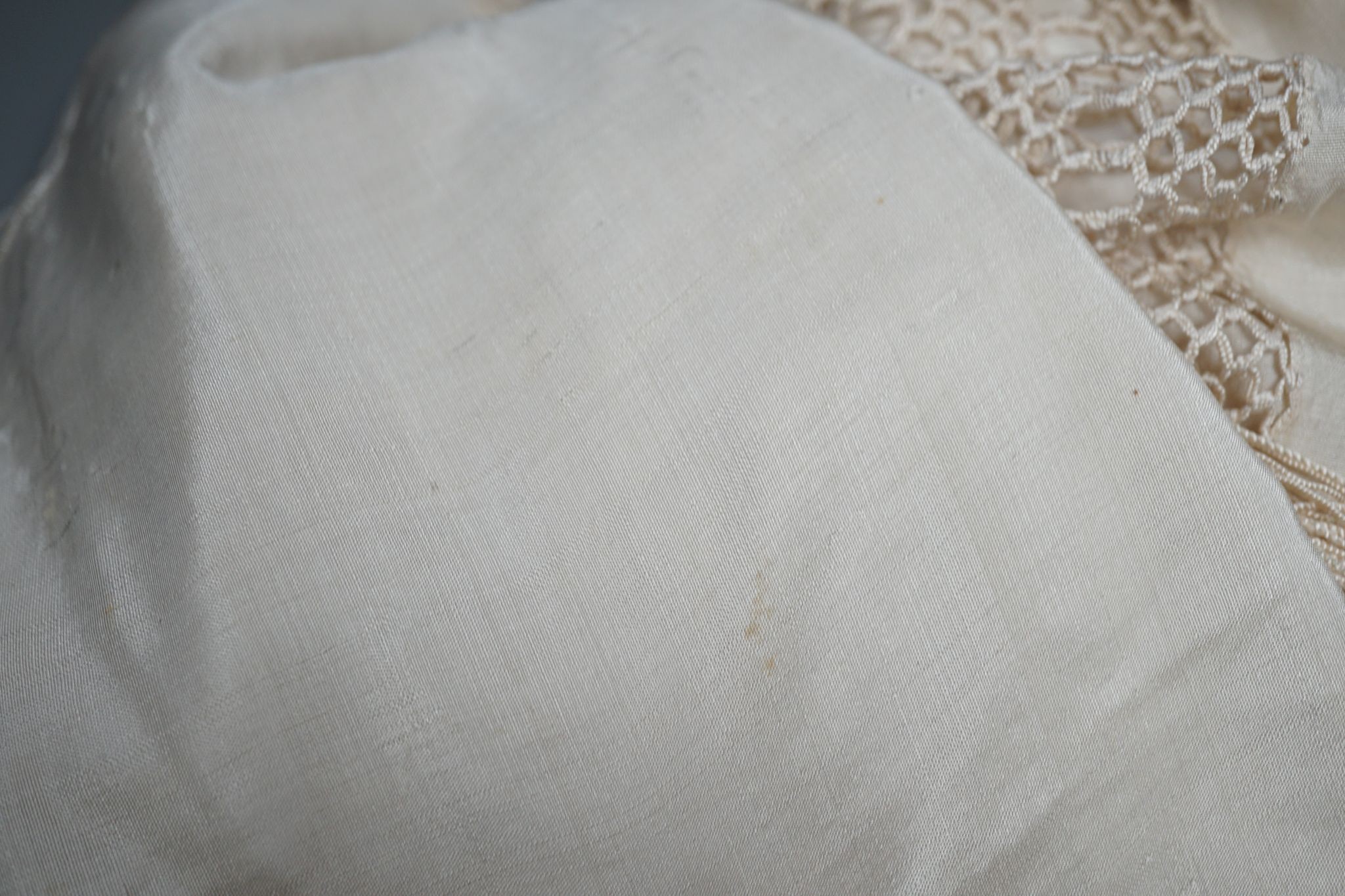A Chinese cream on cream silk, embroidered shawl with a tasselled fringed edge, 160 cms wide x 160 square.